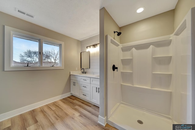 bathroom featuring a shower, vanity, a textured ceiling, and hardwood / wood-style flooring