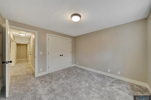 unfurnished bedroom with a closet and light colored carpet