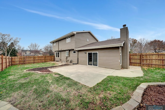 rear view of house featuring a lawn and a patio