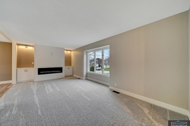 unfurnished living room featuring light carpet and a fireplace