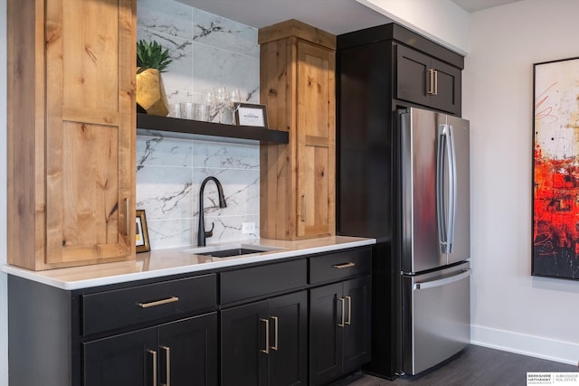 kitchen with tasteful backsplash, stainless steel refrigerator, sink, and dark hardwood / wood-style flooring