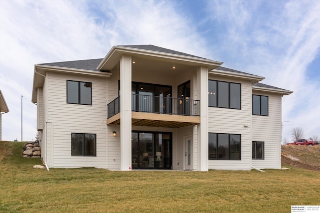 rear view of house with a balcony and a lawn