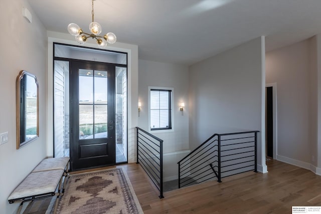 entrance foyer with hardwood / wood-style floors and an inviting chandelier