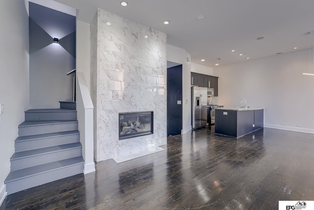 living room with a fireplace, dark hardwood / wood-style floors, and sink