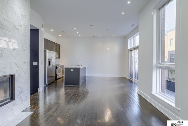 unfurnished living room featuring dark hardwood / wood-style flooring, a fireplace, and sink