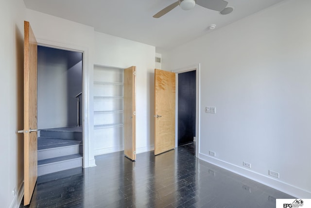 unfurnished bedroom featuring ceiling fan and dark wood-type flooring