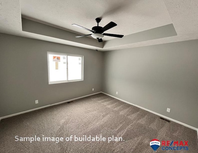 carpeted empty room featuring a raised ceiling, ceiling fan, and a textured ceiling