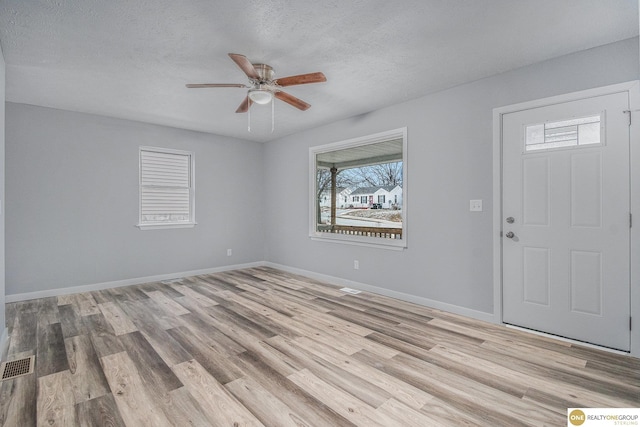 entrance foyer with a textured ceiling, light hardwood / wood-style floors, and ceiling fan