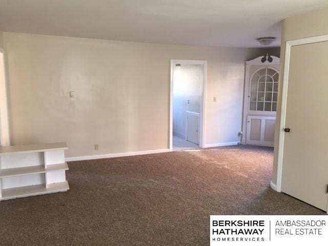 unfurnished room with dark carpet