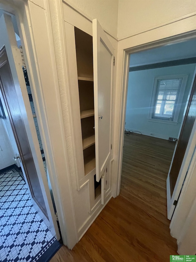 corridor with dark hardwood / wood-style floors