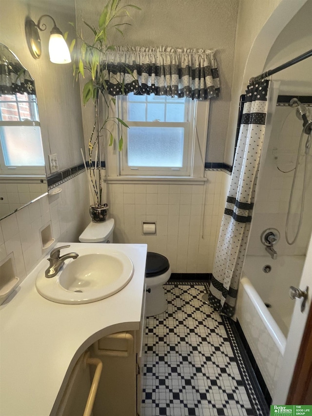 full bathroom with shower / bath combo with shower curtain, tile walls, toilet, and a wealth of natural light