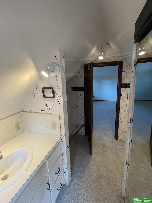 bathroom with vaulted ceiling and vanity