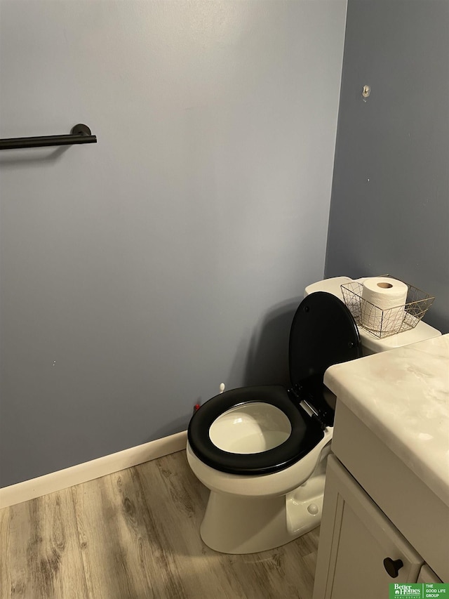 bathroom featuring toilet, wood-type flooring, and vanity