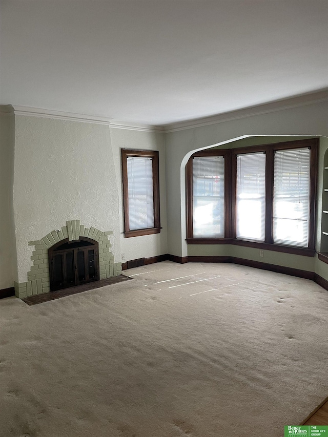 unfurnished living room with carpet floors, crown molding, and a fireplace