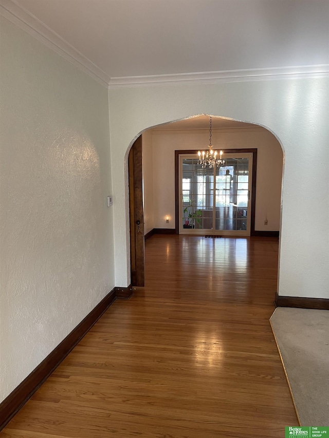 interior space featuring dark hardwood / wood-style floors, ornamental molding, and a notable chandelier