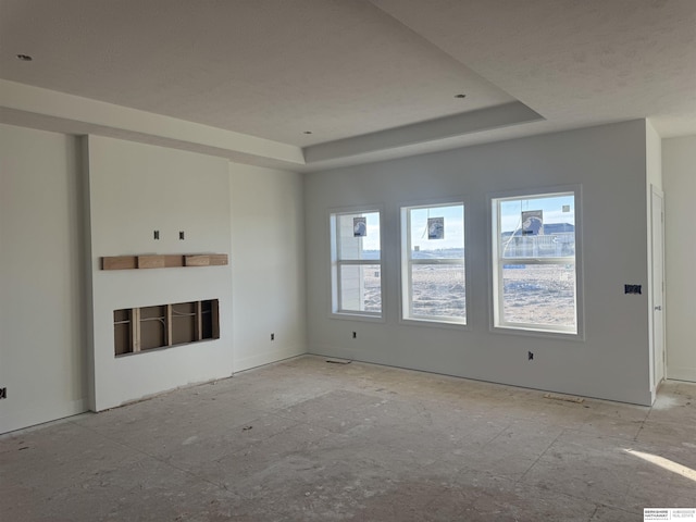 unfurnished living room with a tray ceiling and a fireplace