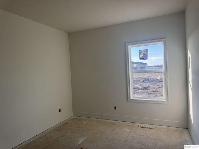 unfurnished room with baseboards