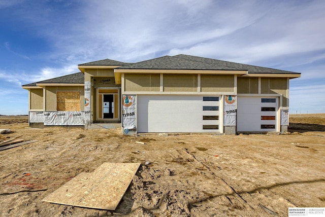 view of front of property with an attached garage and roof with shingles