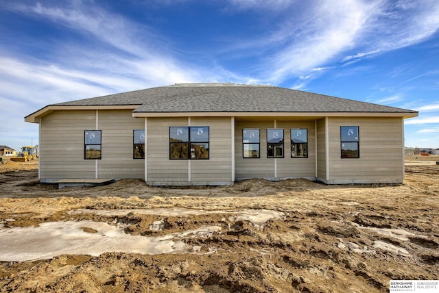 rear view of property featuring a shingled roof