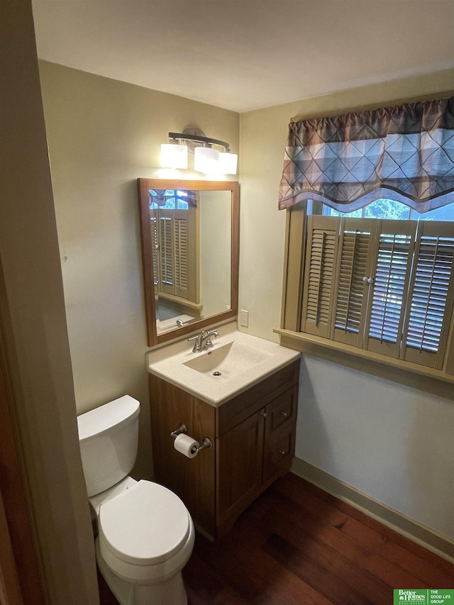 bathroom with hardwood / wood-style floors, vanity, and toilet