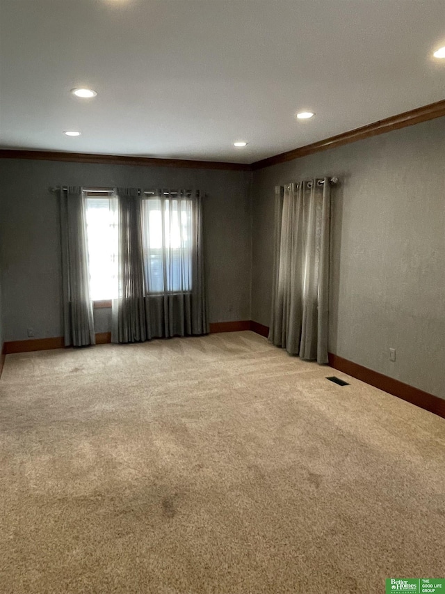 carpeted spare room featuring crown molding