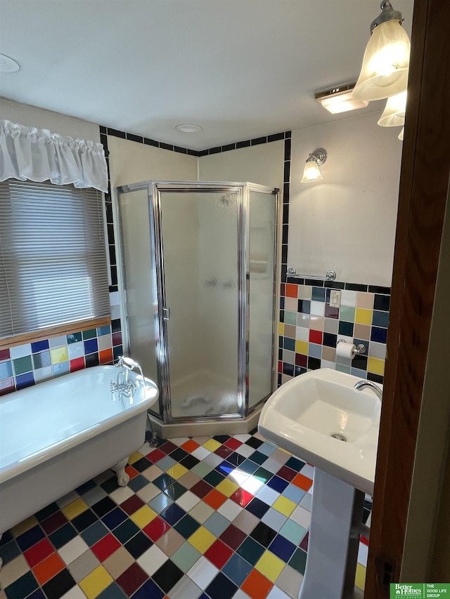 bathroom with a shower with door and tile walls