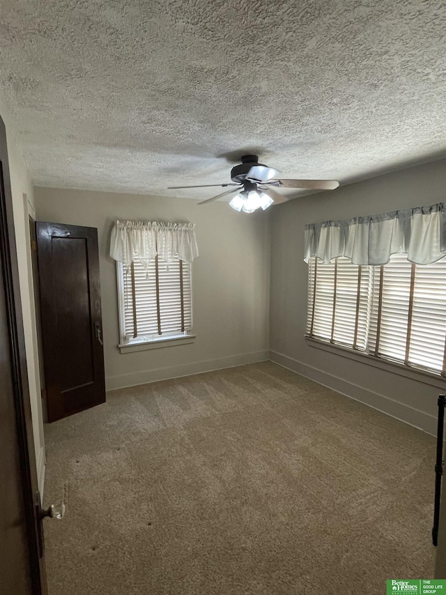 carpeted spare room featuring ceiling fan and a healthy amount of sunlight