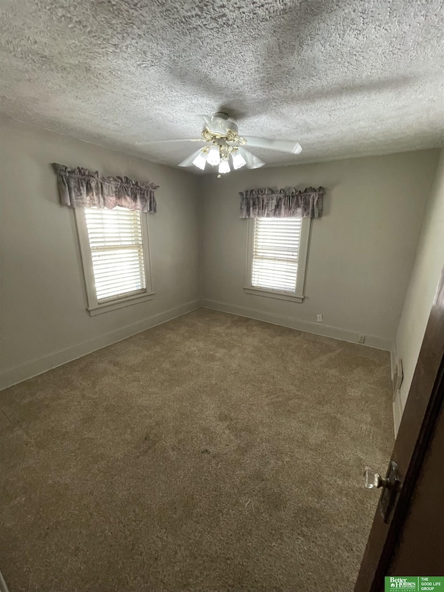 carpeted spare room featuring a textured ceiling and ceiling fan