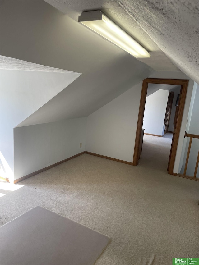 bonus room featuring lofted ceiling and light carpet