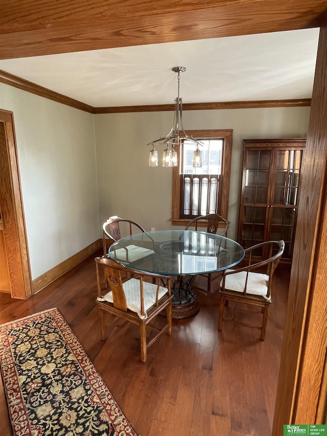 dining area featuring hardwood / wood-style flooring, ornamental molding, and a notable chandelier