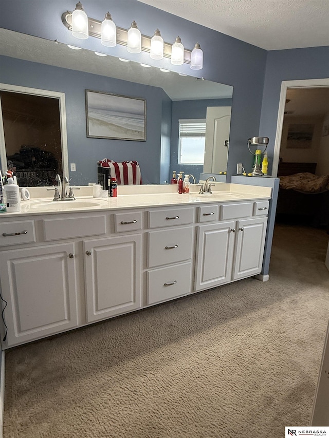 full bathroom with a textured ceiling, double vanity, and a sink