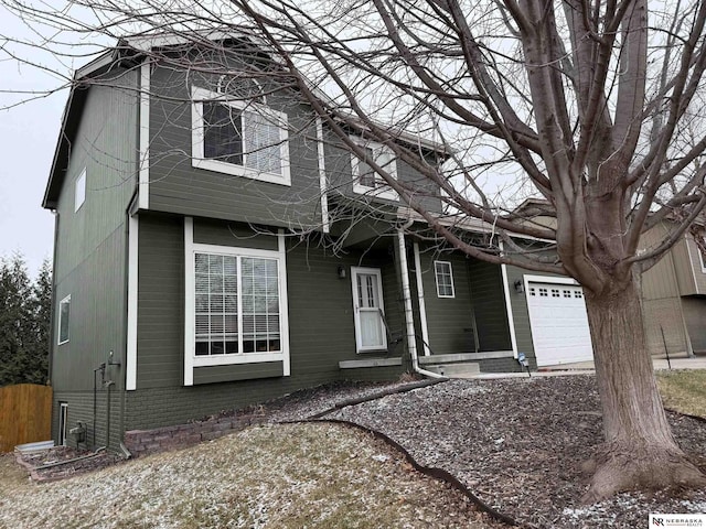 view of front of property with a garage, fence, and brick siding