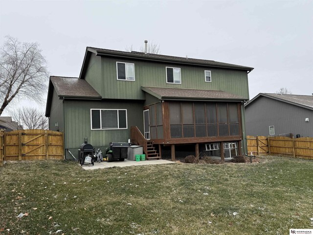 rear view of property featuring a lawn, a patio area, fence, and a sunroom