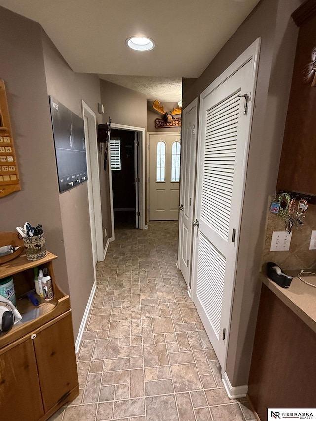 corridor with recessed lighting and baseboards