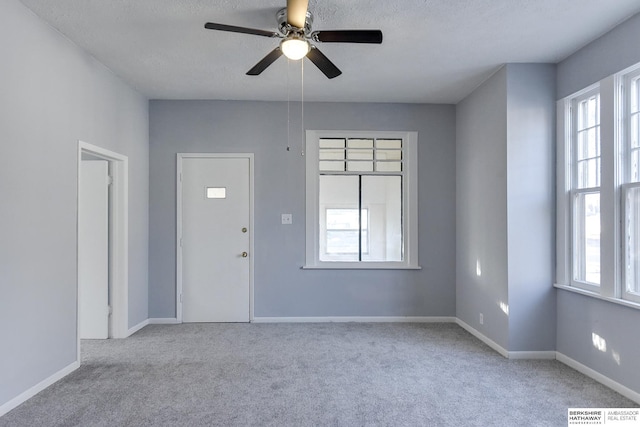 carpeted foyer featuring ceiling fan