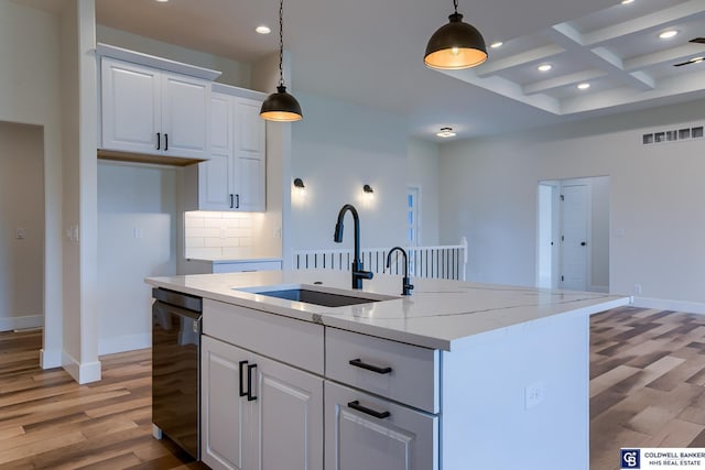 kitchen with sink, white cabinetry, and an island with sink