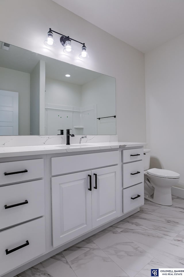 bathroom with a shower, vanity, and toilet