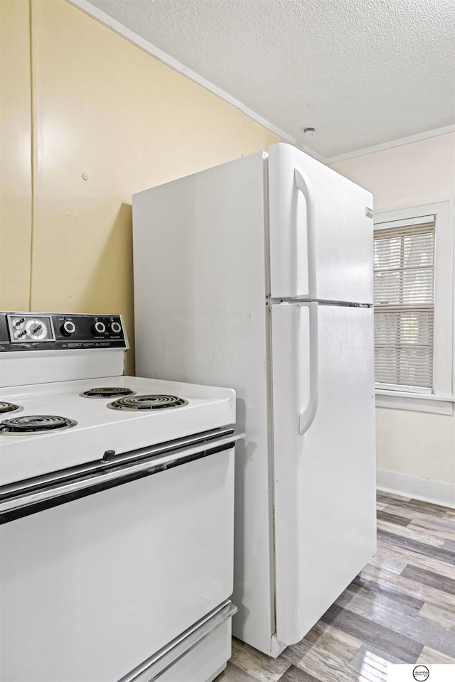 kitchen with a textured ceiling, light wood-type flooring, and electric stove