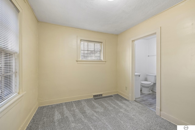 carpeted spare room featuring a textured ceiling