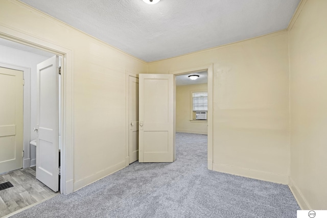 unfurnished bedroom featuring cooling unit, crown molding, and light carpet