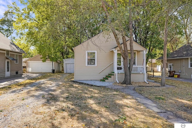 bungalow with an outbuilding, a porch, and a garage