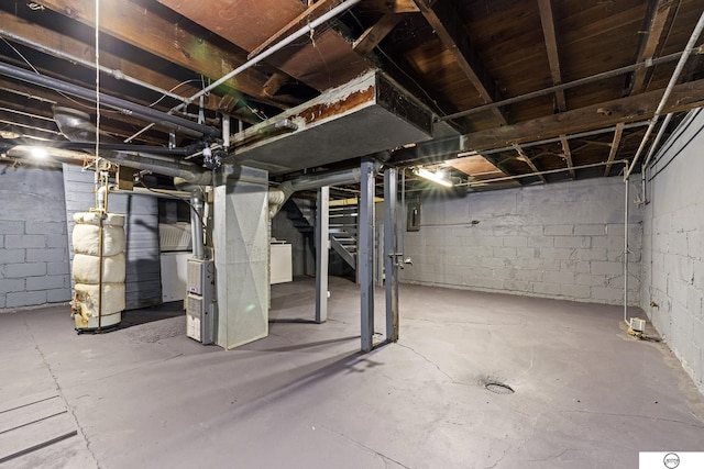 basement with electric panel, heating unit, and washer / clothes dryer