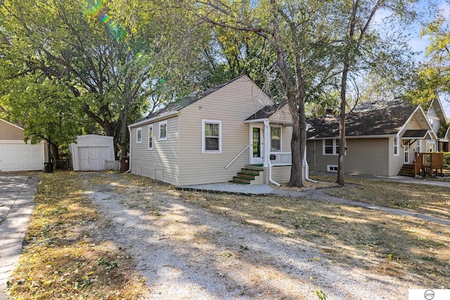 view of front of property featuring a storage unit and a garage