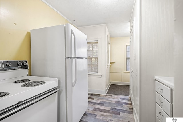 kitchen with hardwood / wood-style floors, white cabinetry, white appliances, and a textured ceiling