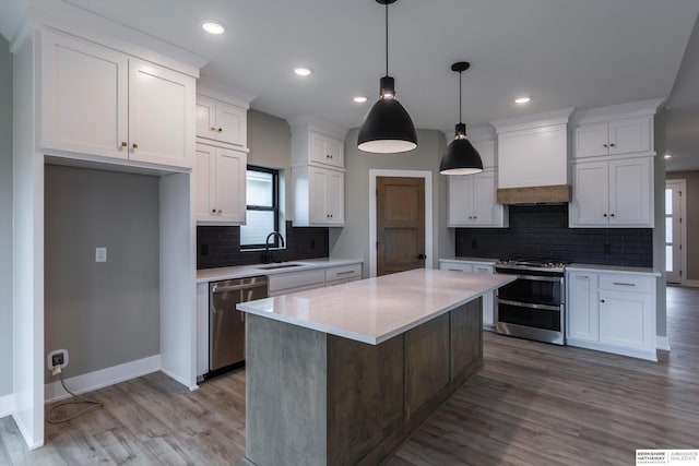 kitchen with sink, a center island, stainless steel appliances, premium range hood, and white cabinets