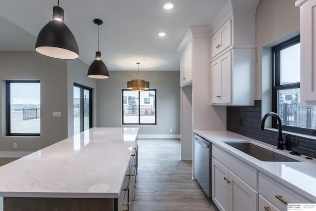 kitchen with white cabinetry, a center island, sink, tasteful backsplash, and stainless steel dishwasher