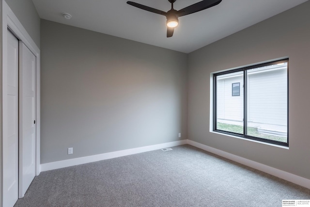 unfurnished bedroom featuring carpet flooring, ceiling fan, and a closet