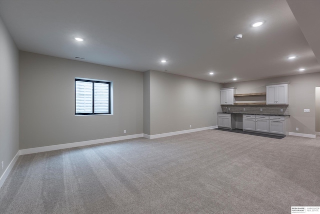 unfurnished living room featuring light carpet