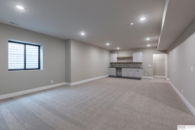 unfurnished living room featuring light carpet