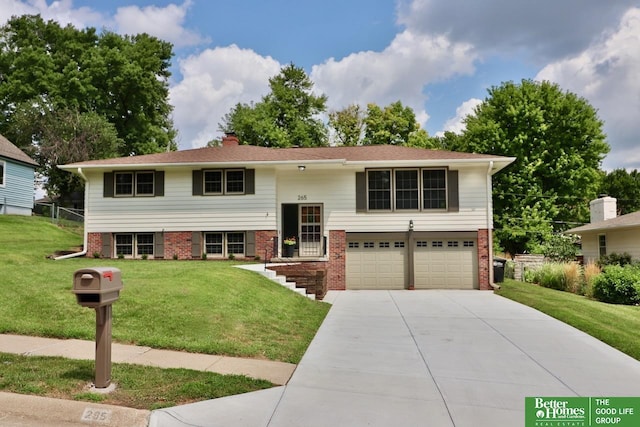 raised ranch with a front lawn and a garage